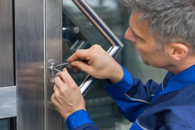 Commercial locksmith working on a business door