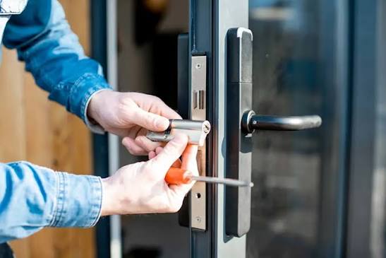 Commercial locksmith working on an office door